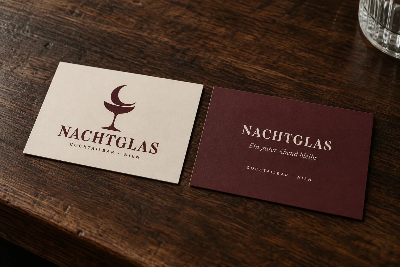 NACHTGLAS-Visitenkarten in Elfenbein und Bordeaux auf einer Holztheke