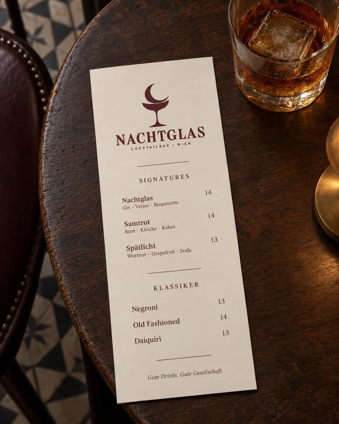 NACHTGLAS-Getränkekarte auf einem Bistrotisch neben einem Glas